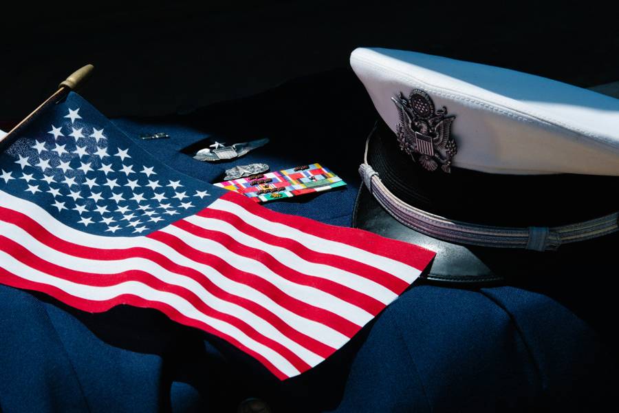 American flag and military dress uniform with medals and cap