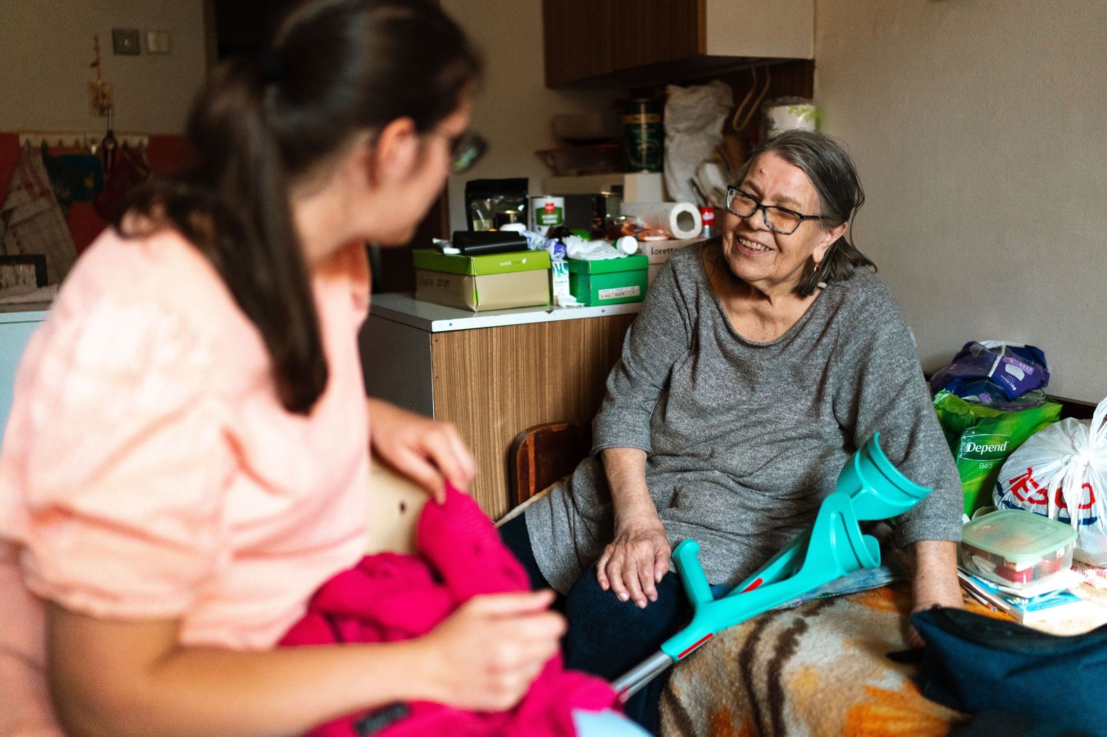 Adult daughter sitting with elderly mother at home