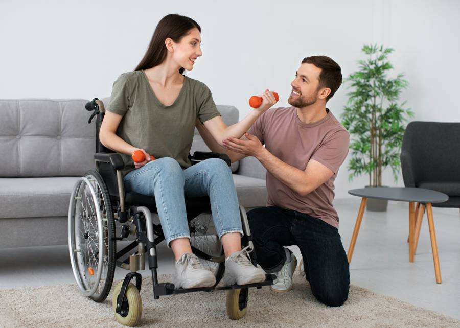 Caregiver assisting woman in wheelchair with light strength exercises